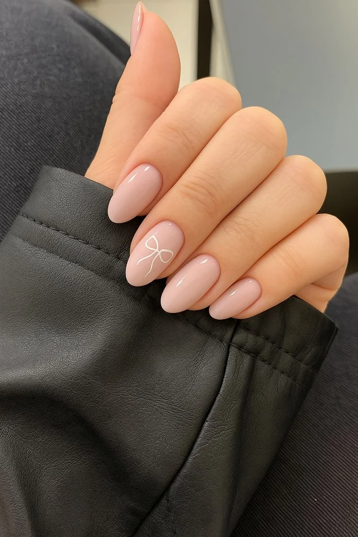 Soft Pink Oval Nails with Delicate White Bow Accent | Minimalist Manicure