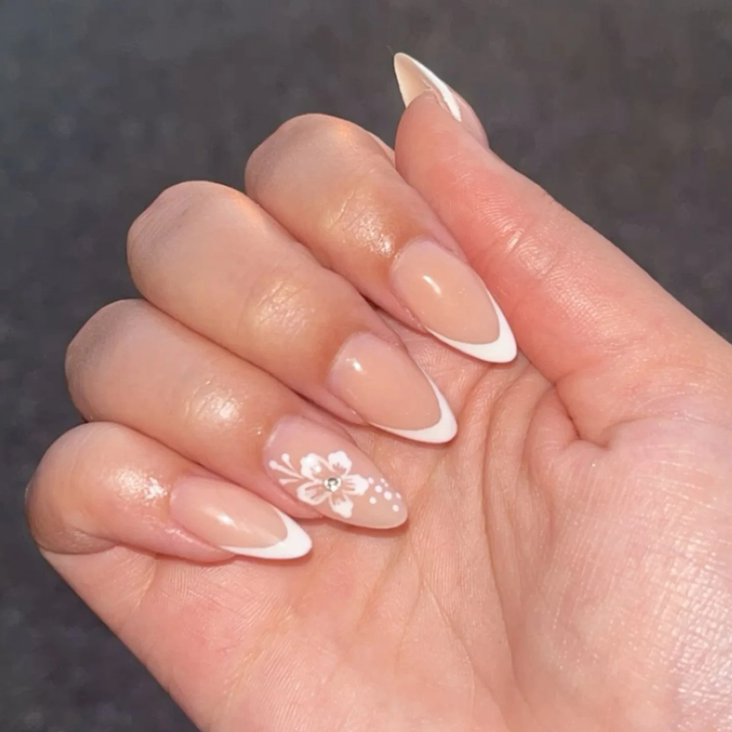 Elegant Nude & White French Tip Almond Nails with Floral Accent